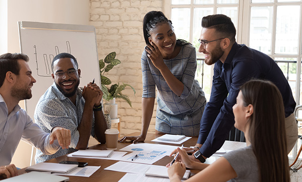 group of professionals collaborating in an office setting with charts and graphs discussing ideas and strategies for project development and success