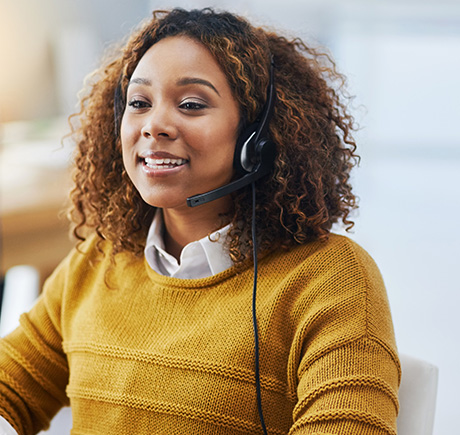 woman with curly hair wearing a headset smiling while sitting at a desk in a comfortable workspace six positive interactions