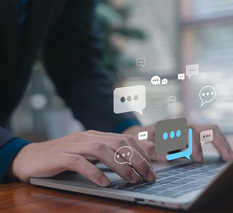 a person's hands typing on a laptop with chat bubbles and messages suggesting communication tools for two-way conversations