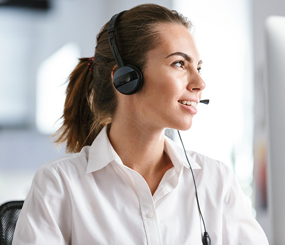 smiling woman wearing a headset in a modern office environment engaged in communication with customers emphasizes professionalism and service skills 3 tips for effective communication