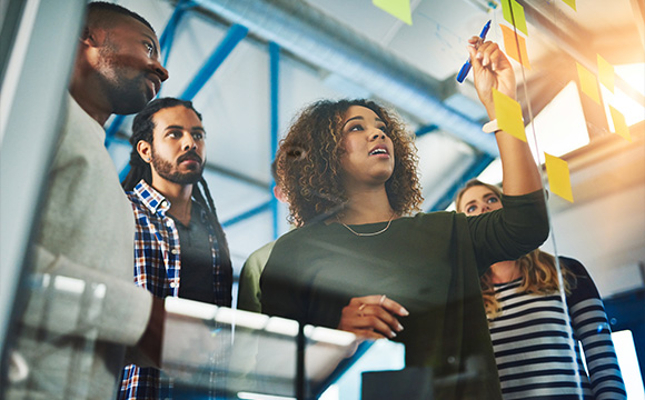 diverse group of professionals collaborating in a creative workspace while brainstorming ideas on sticky notes engaging teamwork for innovative solutions