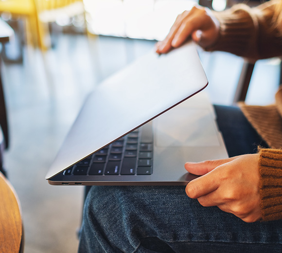 a woman closing a laptop on her lap